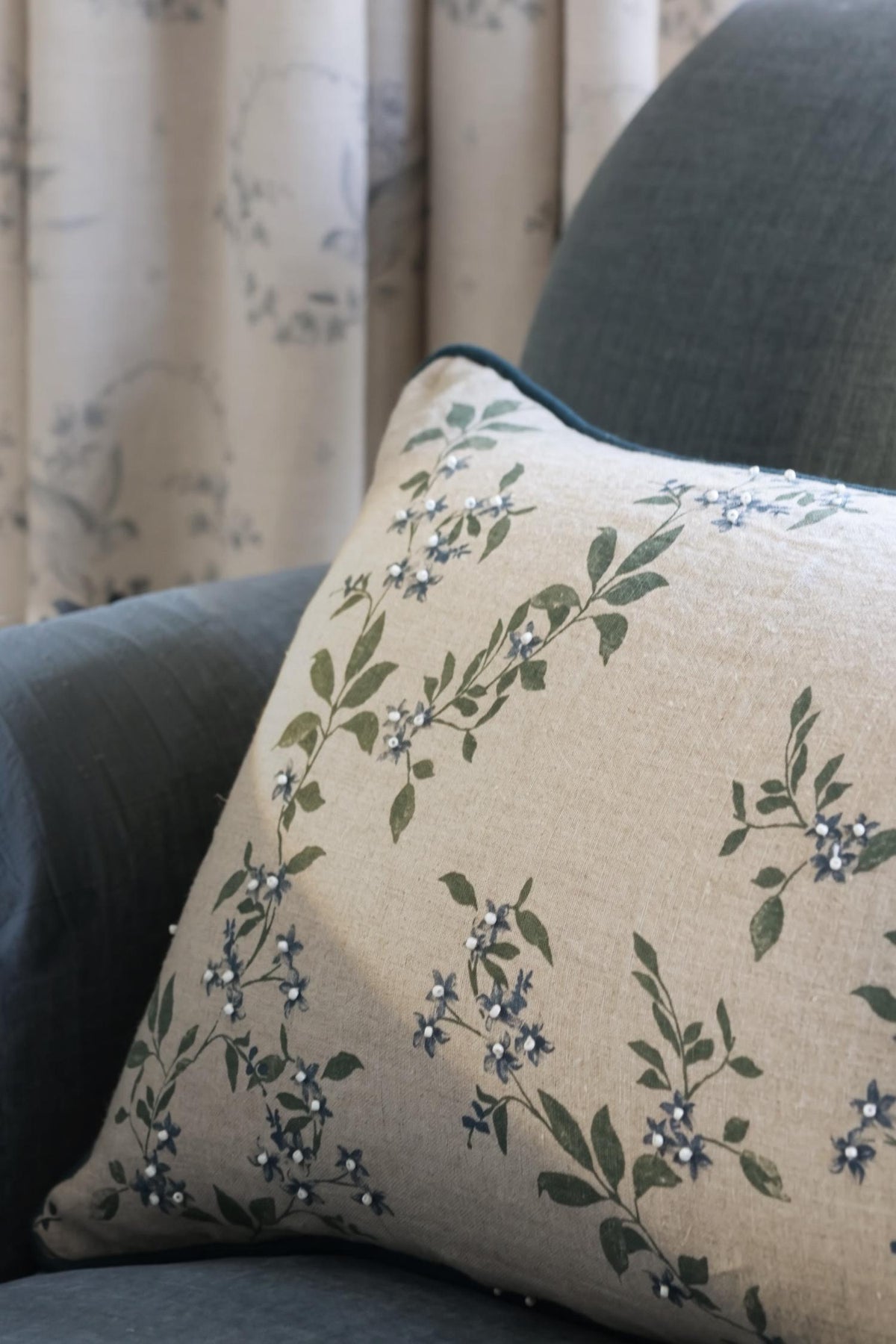 Decorative cushion with floral pattern on a blue sofa