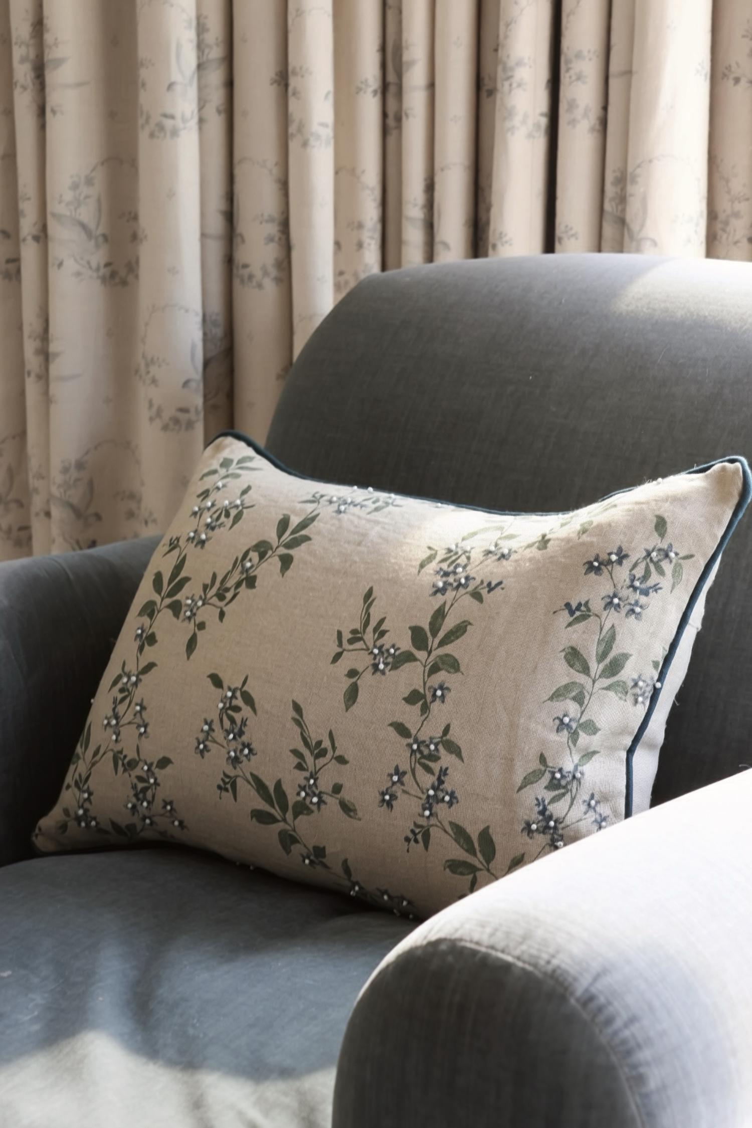 decorative floral pattern linen and blue cushion on blue chair